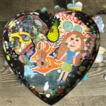 Black clay heart covered with collaged images
